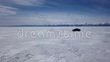 在冬季景观中驾驶汽车的无人机空中景观和高速驾<strong>驶过</strong>冰冻的湖泊。